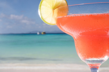 closeup strawberry Daiquiri cocktail at the beach restaurant with beautiful blue sea and sky background