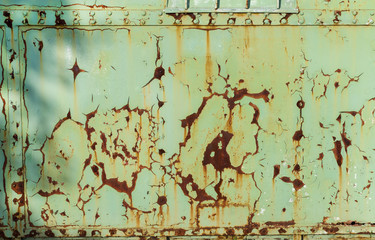 Rusted metal plate - sheet metal with cracked and peeled layer of green paint; background; texture; pattern; copy space; sign board