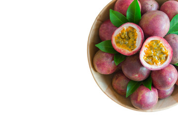 White isolate background fresh passion fruit in wood bowl on wood table in top view flat lay with copy space for background or wallpaper. Ripe passion fruit so sweet and sour. Tropical fruit.