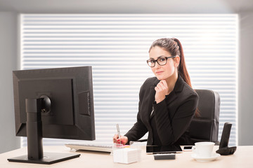 Portrait of a pretty secretary sitting at her desk