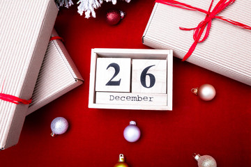 Boxing Day Sale. Calendar with date on red background. Christmas concept. December 26. Christmas ball and gifts. Top view. Copy space.
