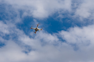 Fototapeta na wymiar Lonely drone flying in blue, cloudy sky