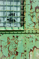 detail of window of old and rusty green iron trailer