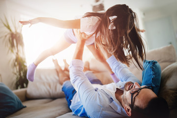 Portrait of father and daughter playing at home