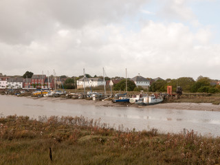 Naklejka premium row of moored private boats in estuary autumn day