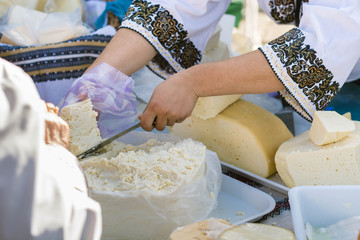 Different types of traditional Romanian cheese on a table in a market.