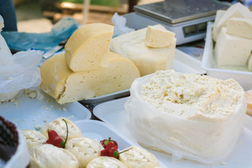 Different types of traditional Romanian cheese on a table in a market.