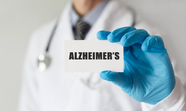 Doctor holding a card with text ALZHEIMERS, medical concept