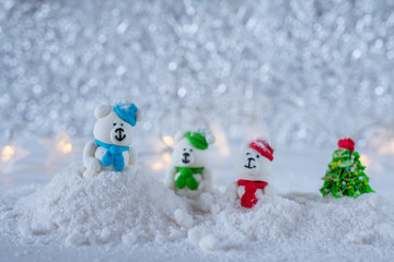 Christmas Composition.  New Year's toys - Three sugar candy bears playing  in the snow on bokeh background. Selective focus