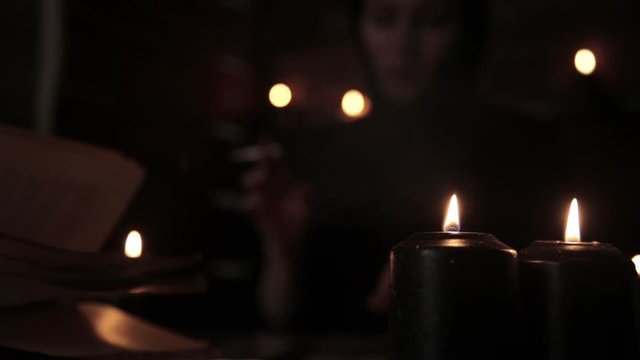mystical beautiful female fortune teller, smoking a cigarette and laying out cards with black candlelight