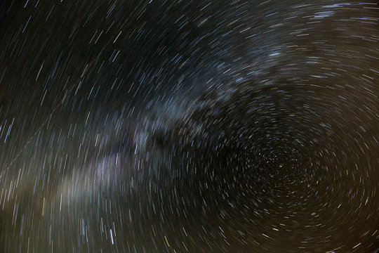 The movement of the stars and the milky way in the night sky around the North star. Night photography.
