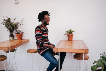 Young happy afro american man sitting in cafe