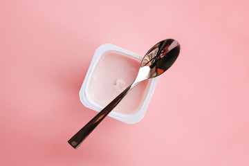 Strawberry yogurt or pudding  in white plastic cup on pink background with copy space. Strawberry...