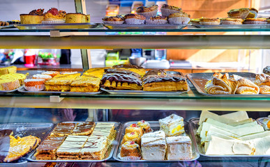 Assortment of gourmet sweet pastries in bakery window.