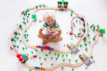 Obraz na płótnie Canvas Child with toy train. Kids wooden railway.