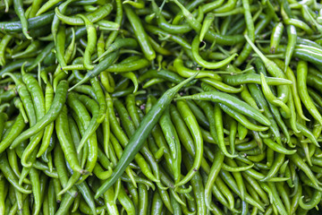 Green chilli peppers closeup on rustic market . Greece.