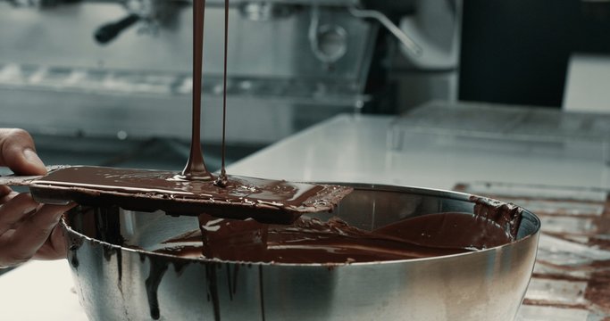 liquid chocolate in chocolate fabric, making chocolate bars. pouring chocolate