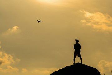 Silhouette of photographer with drone over the mountain, tphotographer and ransportation concept