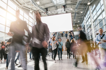 crowd of anonymous blurred business people at a trade fair hall