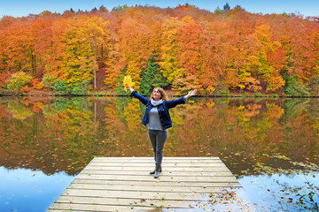 Fototapeta na wymiar Happy woman enjoys leisure at river in autumn.
