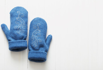 blue mittens on white wooden background