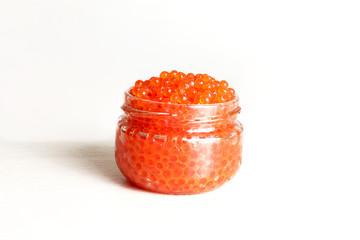 Red caviar in glass cans on a white background