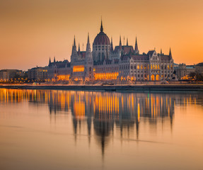 Fototapeta na wymiar Budapes, Hungary - Beautiful orange sunrise at the Hungarian Parliament with reflection on the River Danube
