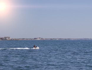 people riding on jet skis in the sea on a sunny day and clear skies