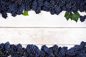 Blue grapes on white old boards.