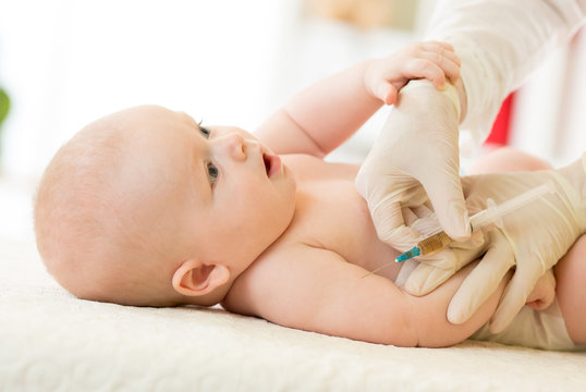 Close-up shot of pediatrician giving baby intramuscular injection in arm