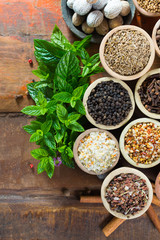 Variety of different asian and middle east spices, colorful assortment, on old wooden table top view