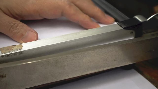 Man cut white paper with paper cutting guillotine