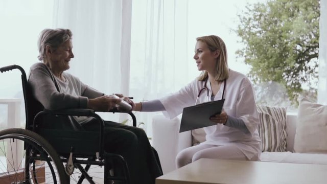 Health visitor and a senior woman during home visit.