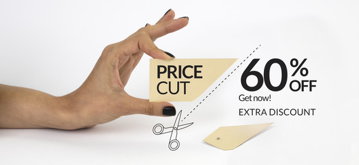 Female hand with black nails, holding scissors and cutting a price tag. Isolated on grey background.