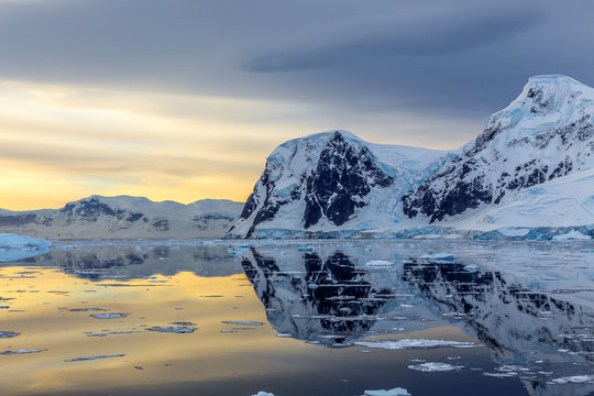 Cold still water of antarctic lagoon with glaciers and mountains in the background, Antarctica