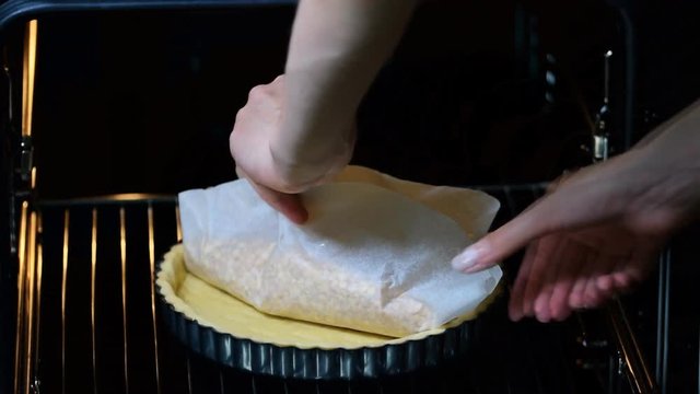 A woman baking a crust for a tart.