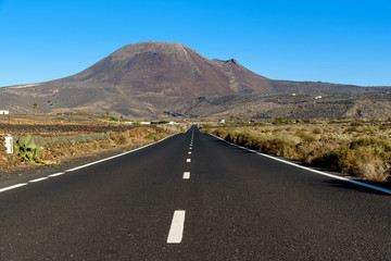 empty road at Lanzarote and volcano background, Canary islands, Spain