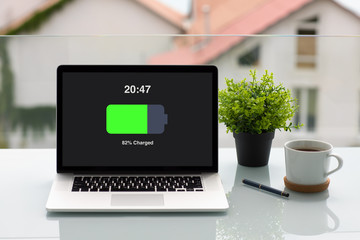 computer laptop with charged battery screen on table in cafe