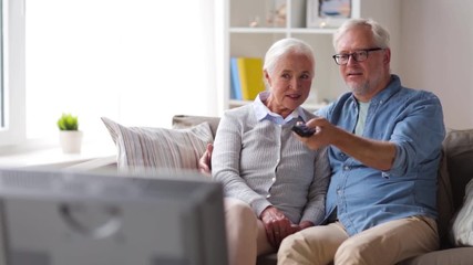 happy senior couple watching tv at home - Powered by Adobe