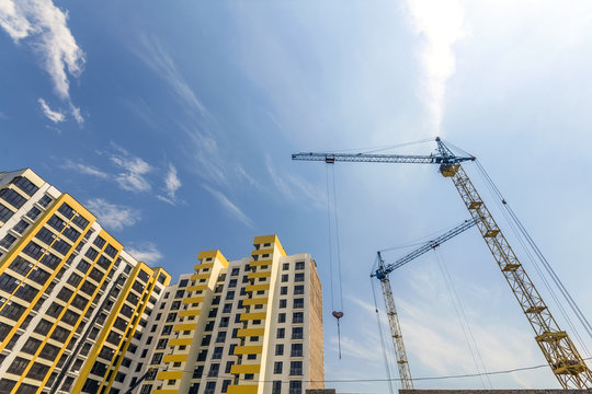 Crane And High Rise Building Under Construction Against Blue Sky. Modern Architecture Background