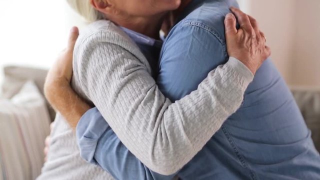 happy senior couple hugging at home