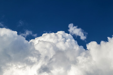 Blue sky with puffy white clouds in bright clear sunny day