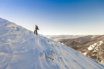 A male mountaineer walking uphill on a glacier. Mountaineer reaches the top of a snowy mountain in...