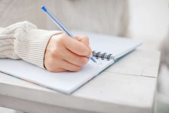 Woman writing pen in notebook