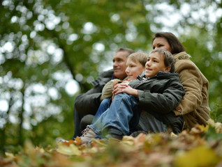Fototapeta premium Happy smiling family sitting on leaves