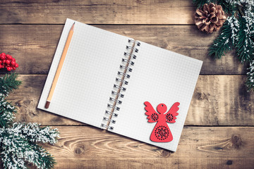 Blank paper notebook on brown wooden table background. Top view