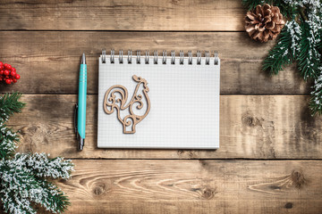 Blank paper notebook on brown wooden table background. Top view