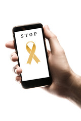 Hand holding smartphone, blank screen with gold ribbon isolated on white background. World Cancer Day. Childhood cancer concept