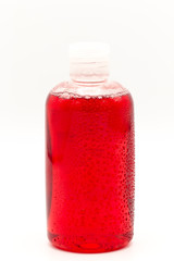 red cleaning equipment isolated on a white background. water drop on colored plastic bottles with Detergent isolated on white background .