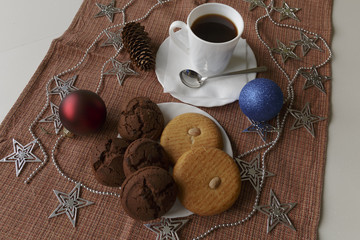 Cookies and Americano coffee. Italian almond and chocolate cookies for Christmas breakfast. Napkin with brown cage as background.